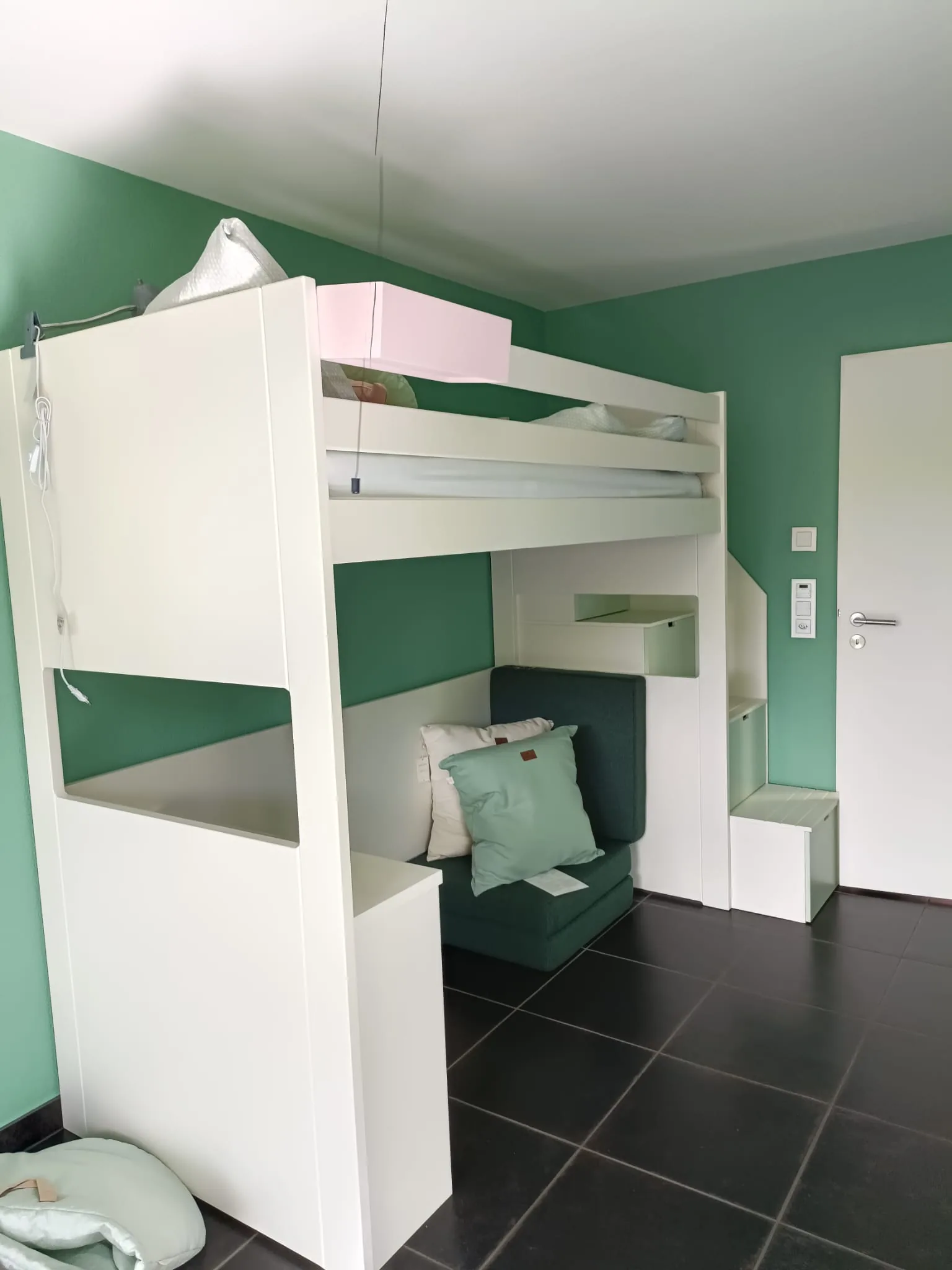 Weisses Hochbett mit Lounge-Bereich, grüne Wandfarbe